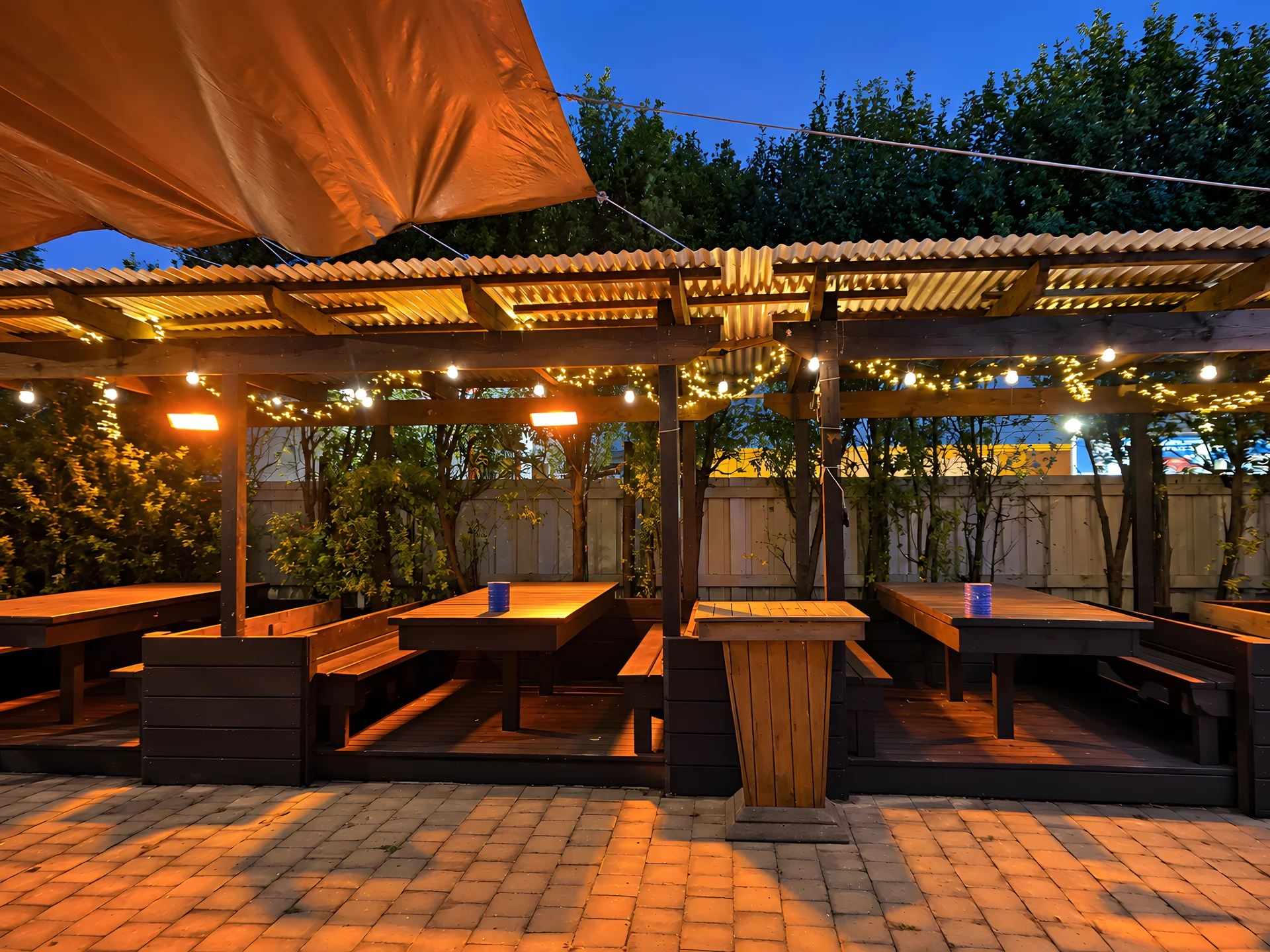 Group of friends sharing drinks around a long outdoor table